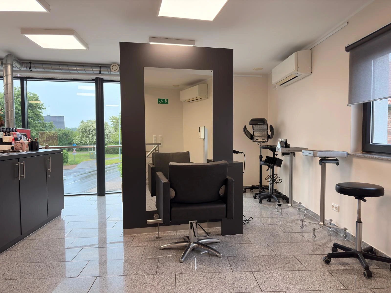 Gründliche Reinigung von Friseursalons: Hygienisch sauberer Arbeitsplatz und gepflegter Natursteinboden durch regelmäßige Unterhaltsreinigung.