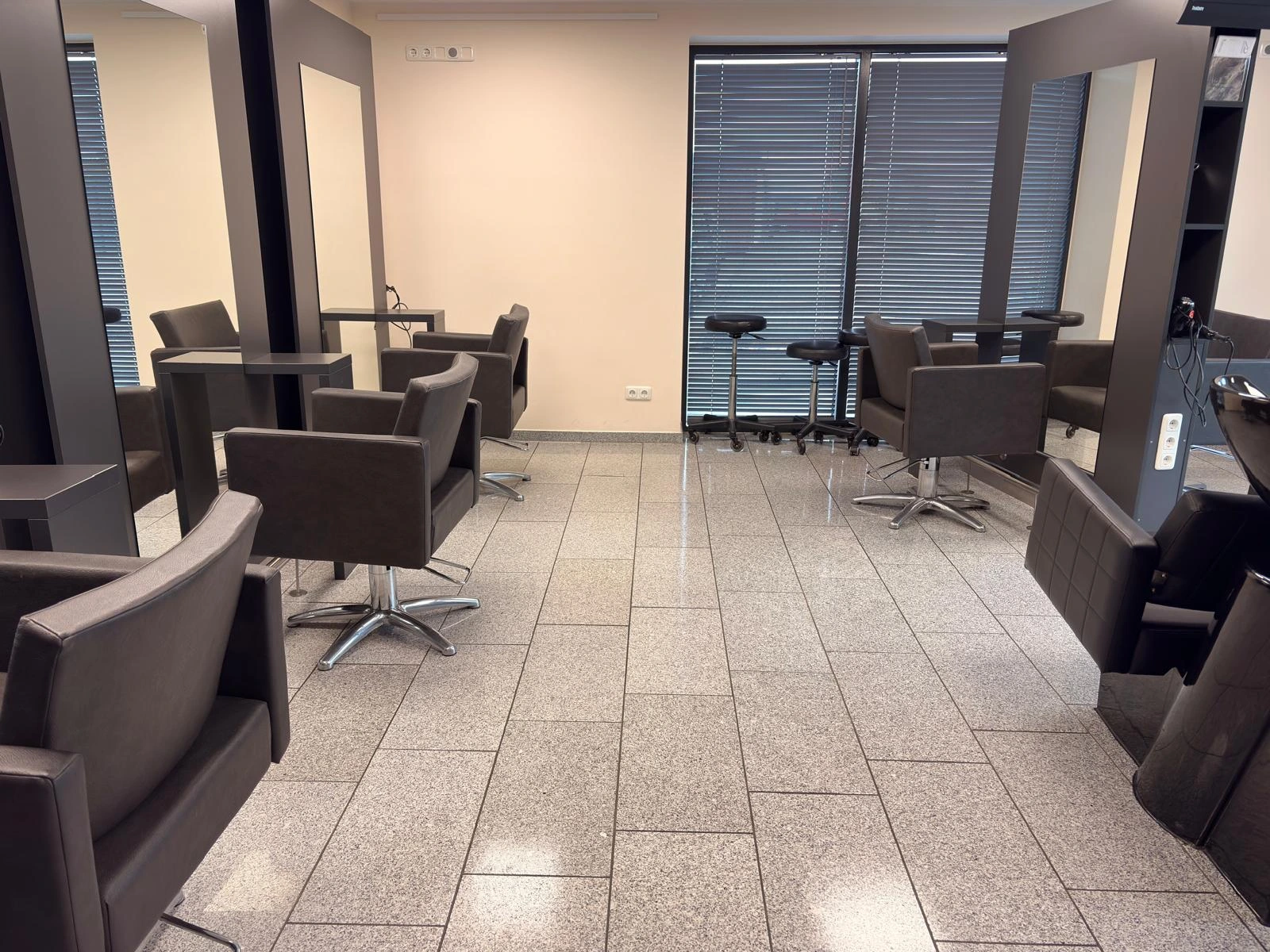 Sauberkeit für Kundenbereiche: Fachmännisch gereinigter Salon mit fokus auf staubfreie Oberflächen und einen perfekt gewischten Boden.